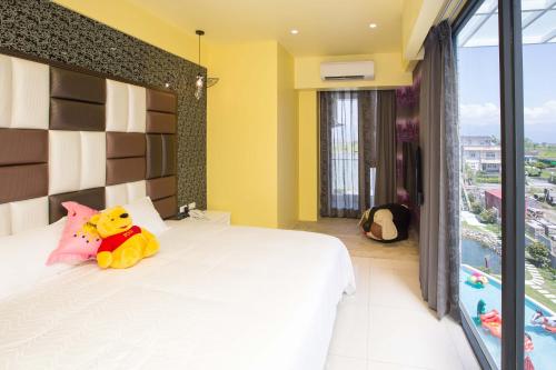 a bedroom with a bed with a stuffed animal on it at Diudiu Dang Paternity B&B in Dongshan