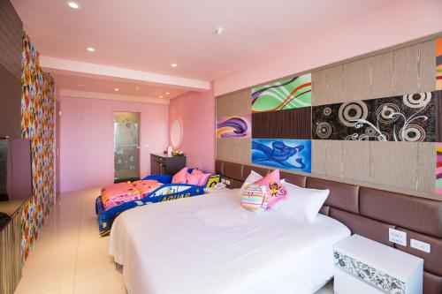 two beds in a bedroom with pink walls at Diudiu Dang Paternity B&B in Dongshan