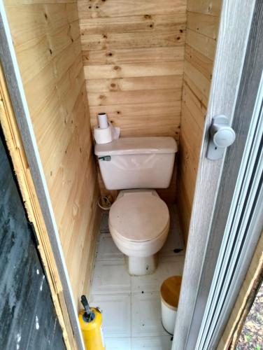 a small bathroom with a toilet in a wooden cabin at Chalet CAJIK Project, tipo Nordico in Cajicá