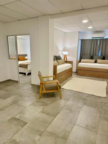 a room with two beds and a chair in it at Concepcion Apart in Concepción