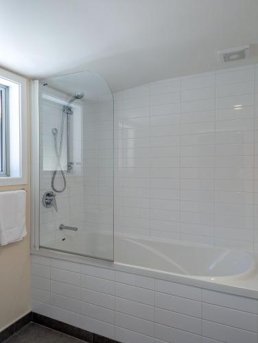 a white bathroom with a tub and a shower at Mt Potts Lodge in Ashburton Lakes