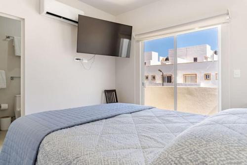 a bedroom with a large bed and a large window at SHINYADO Casa de Huéspedes Cabo San Lucas in Cabo San Lucas