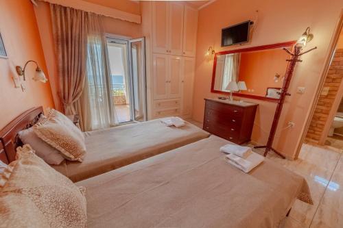a hotel room with two beds and a mirror at Oceanfront Studio at Paramonas Beach in Paramonas