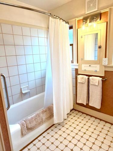 ein Badezimmer mit Badewanne und Dusche sowie Handtüchern. in der Unterkunft Riverpath Inn in Eugene