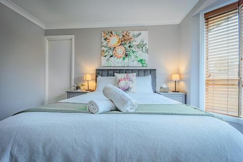 ein weißes Schlafzimmer mit einem großen Bett und zwei Kissen in der Unterkunft Tranquility in Oberon