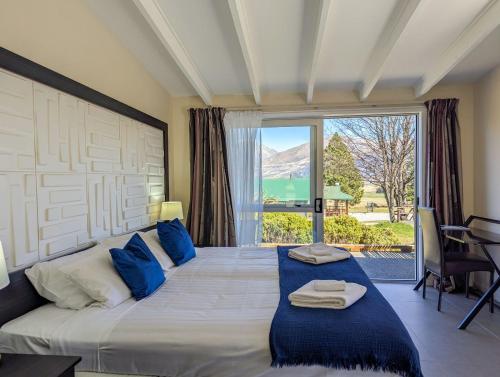 a bedroom with a large bed with a large window at Mt Potts Lodge in Ashburton Lakes