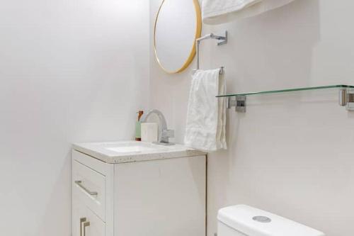 a white bathroom with a sink and a mirror at SHINYADO Casa de Huéspedes Cabo San Lucas in Cabo San Lucas
