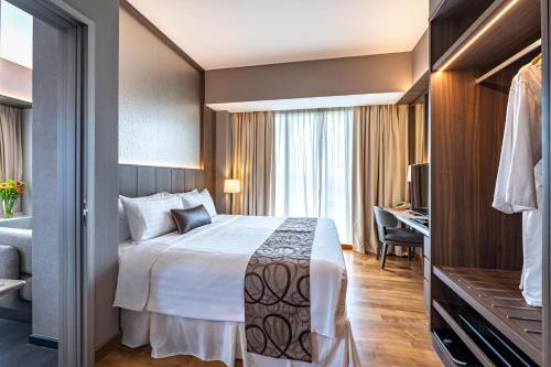 a hotel room with a bed and a desk at Park Avenue Rochester in Singapore