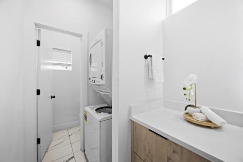 a white bathroom with a tub and a sink at Boho-Mod Studio at East Downtown in Houston