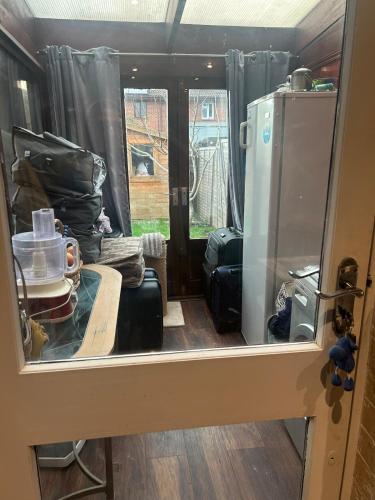 a room with a refrigerator and a table in a trailer at Stylish Home With Full Amenities in Yiewsley