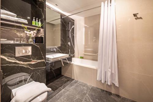 a bathroom with a shower and a toilet and a sink at Park Avenue Rochester in Singapore