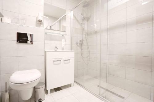a white bathroom with a toilet and a shower at Hotel Park in Vogošća