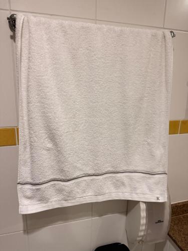 a towel hanging over a toilet in a bathroom at Apartamento Jaragua do sul in Jaraguá do Sul