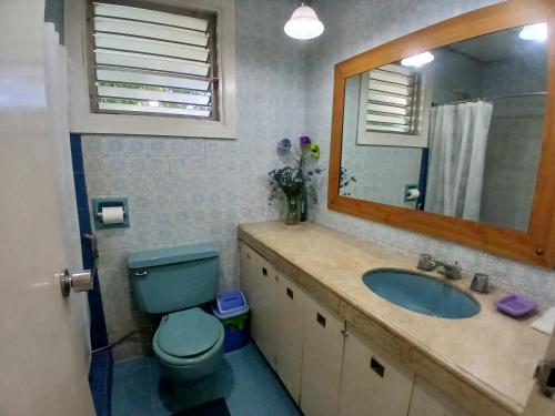 a bathroom with a blue toilet and a sink at Casa Joaquin BnB in Manila