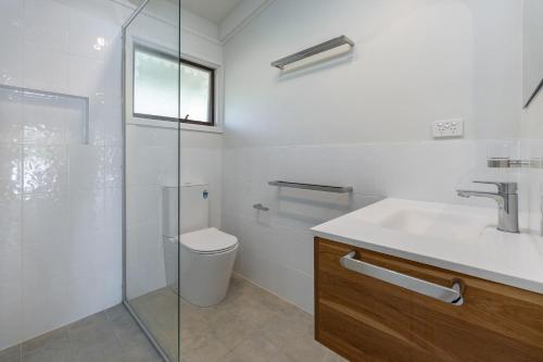 a bathroom with a toilet and a sink and a shower at Sandpiper 11 in Smiths Lake