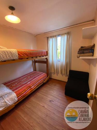 a room with two bunk beds and a window at cabañas canemar in Hueyilemu