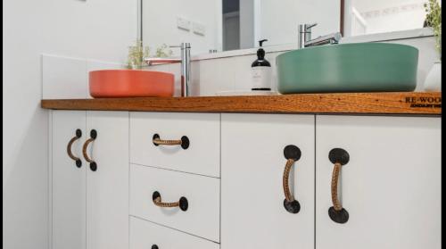 a kitchen with white cabinets and a sink at East Jindabyne- Cavallino 3 bedroom home in Jindabyne