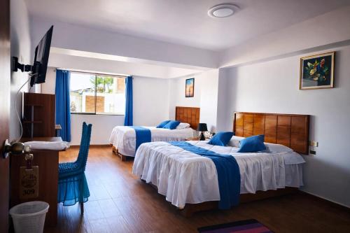 a hotel room with two beds and a window at Mi Hacienda Pacucha in Andahuaylas
