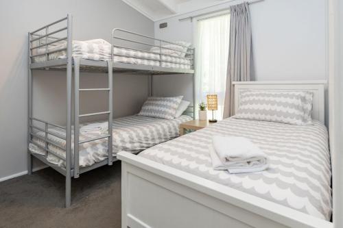 a bedroom with two bunk beds next to a window at Sandpiper 4 in Smiths Lake