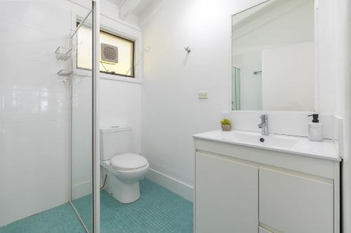 a white bathroom with a toilet and a sink at Sandpiper 4 in Smiths Lake