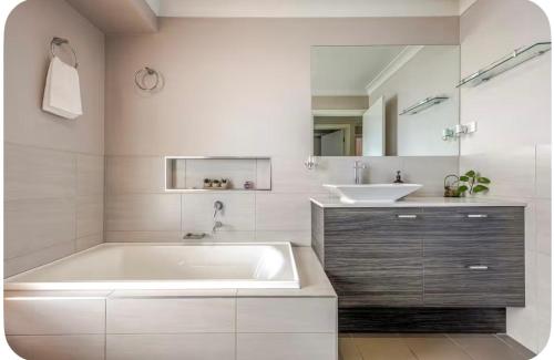 ein Badezimmer mit einer großen Badewanne und einem Waschbecken in der Unterkunft Tranquility in Oberon