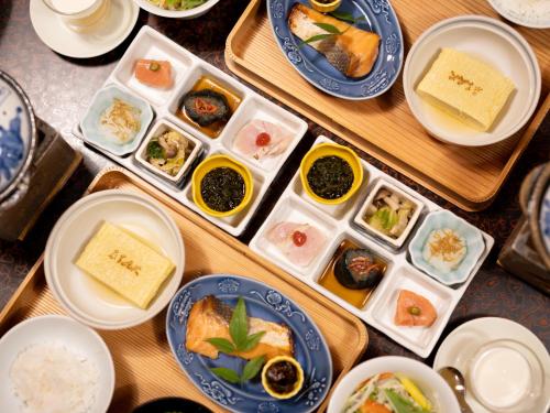 a table with plates of food and bowls of food at Futsukaichi Hot Spring - Daimaru Besso in Chikushino