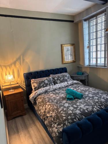a bedroom with a bed with a blue head board at The workshop in King's Lynn