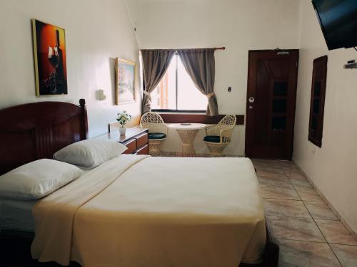 a bedroom with a bed and a desk and a table at Hotel Garant & Suites in Boca Chica