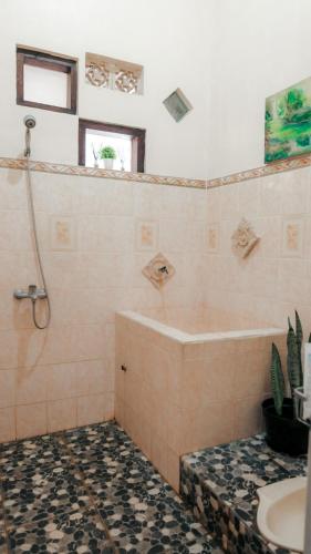 a bathroom with a tub and a sink at Jeru Homestay in Situbondo