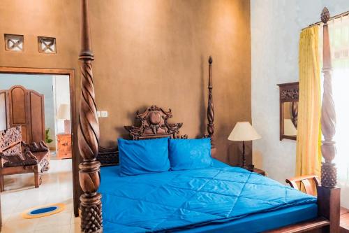 a bedroom with a bed with a blue comforter at Jeru Homestay in Situbondo