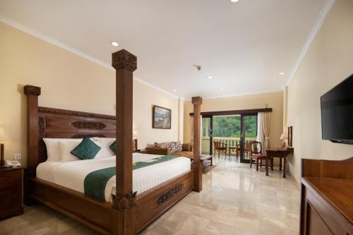 a bedroom with a bed and a television and a table at Ayung Resort Ubud in Payangan