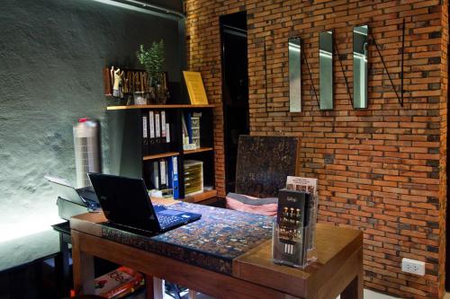 a desk with a laptop computer on top of it at 3 Laan House in Chiang Mai