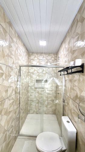 a bathroom with a toilet and a glass shower at Hotel Maracá in Boa Vista