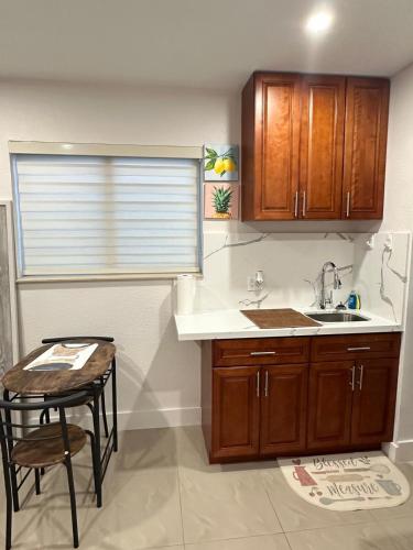 a kitchen with wooden cabinets and a sink and a table at Miramar's Studio in Miramar