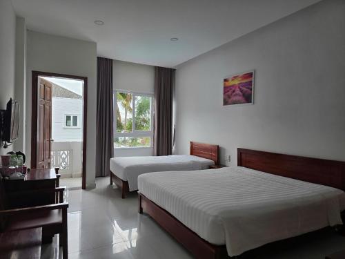 a hotel room with two beds and a television at Laverder Resort in Phú Quốc