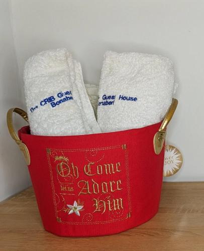Ein roter Eimer voller Handtücher stand auf einem Tisch. in der Unterkunft The Crib in Bonabéri