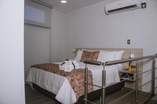 a small bedroom with a bed with white walls at Aparta Hotel Loft 1985 Awaliba in Puerto Gaitán