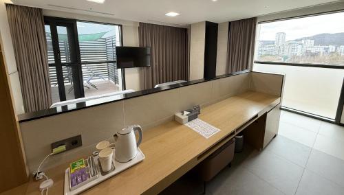 a reception desk in a room with a large window at Hotel Skypark DaejeonⅠ in Daejeon