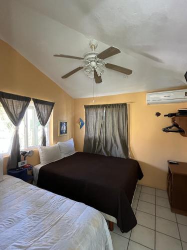 ein Schlafzimmer mit zwei Betten und einem Deckenventilator in der Unterkunft Coco Cabanas Loreto in Loreto