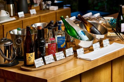 a table with bottles of wine and dishes on it at Tassel Hotel Sanjo Shirakawa in Kyoto