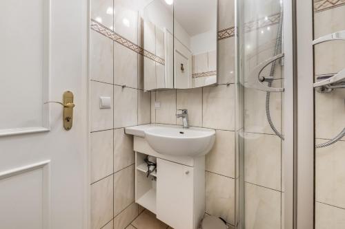 a white bathroom with a sink and a shower at LH Dünenblick Wohnung 9 in Wenningstedt