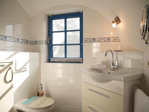 a white bathroom with a toilet and a sink at Mohnblume in Am Schwarzen Busch