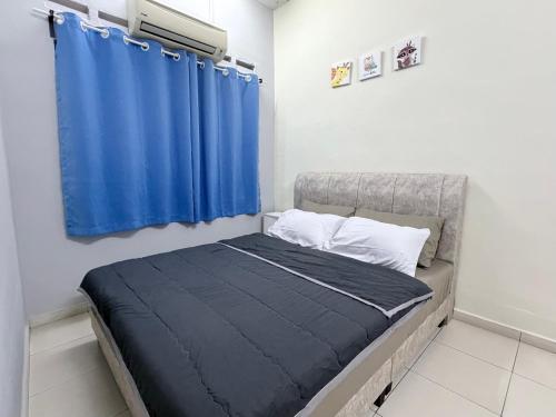 a bedroom with a bed with a blue curtain at Greeny Homestay in Muar