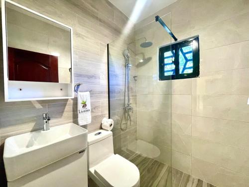 a bathroom with a toilet and a sink and a shower at Villa Lionisia in Puerto Plata