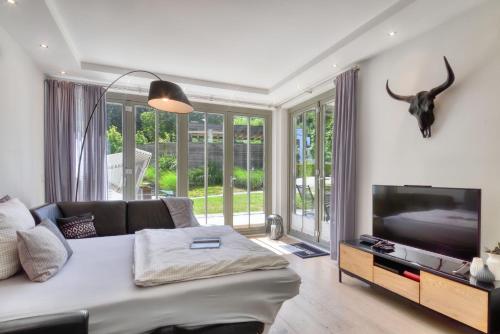 a living room with a couch and a flat screen tv at Ferienwohnung Baltic Lounge in der Villa Amalie Binz in Binz