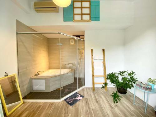 a bathroom with a tub and a glass shower at Xiangyang Tianyuan in Sanyi