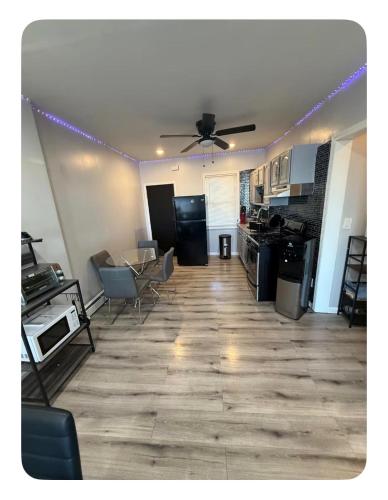 a living room with a ceiling fan and a kitchen at EWRBNB- Private bedroom in a Well Spaced Shared Apartment 4 in Elizabeth
