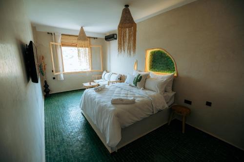 a bedroom with a large bed and a window at Surf Lodge Tamraght in Tamraght Ouzdar