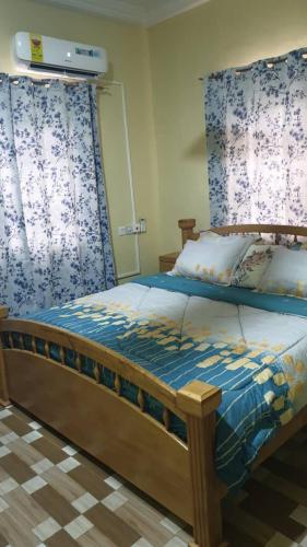 a bedroom with a bed with blue and white curtains at Grace View Villa in Trofwi