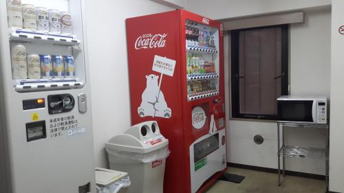 a coca cola vending machine in a room at Hotel Crown Hills Sagamihara in Sagamihara